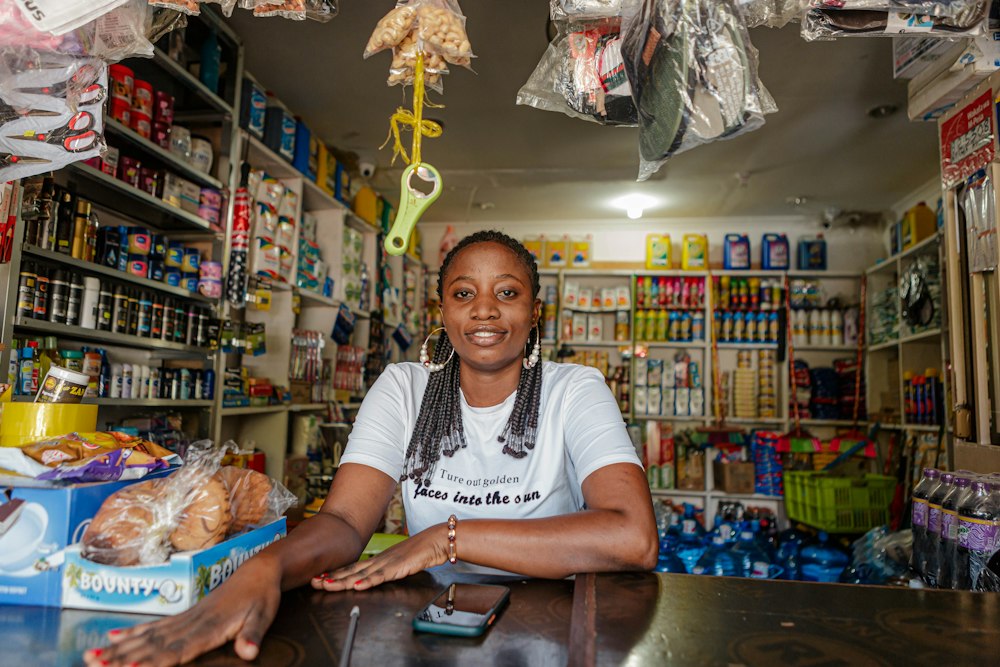 A shop owner smiling behind the counter of her general store