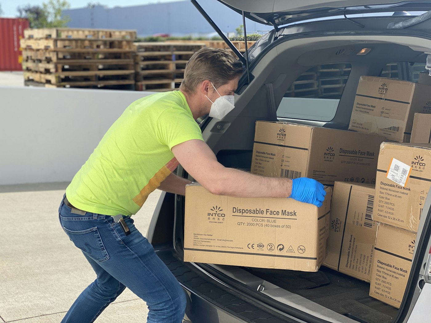 A driver loading boxes of goods into a vehicle for delivery