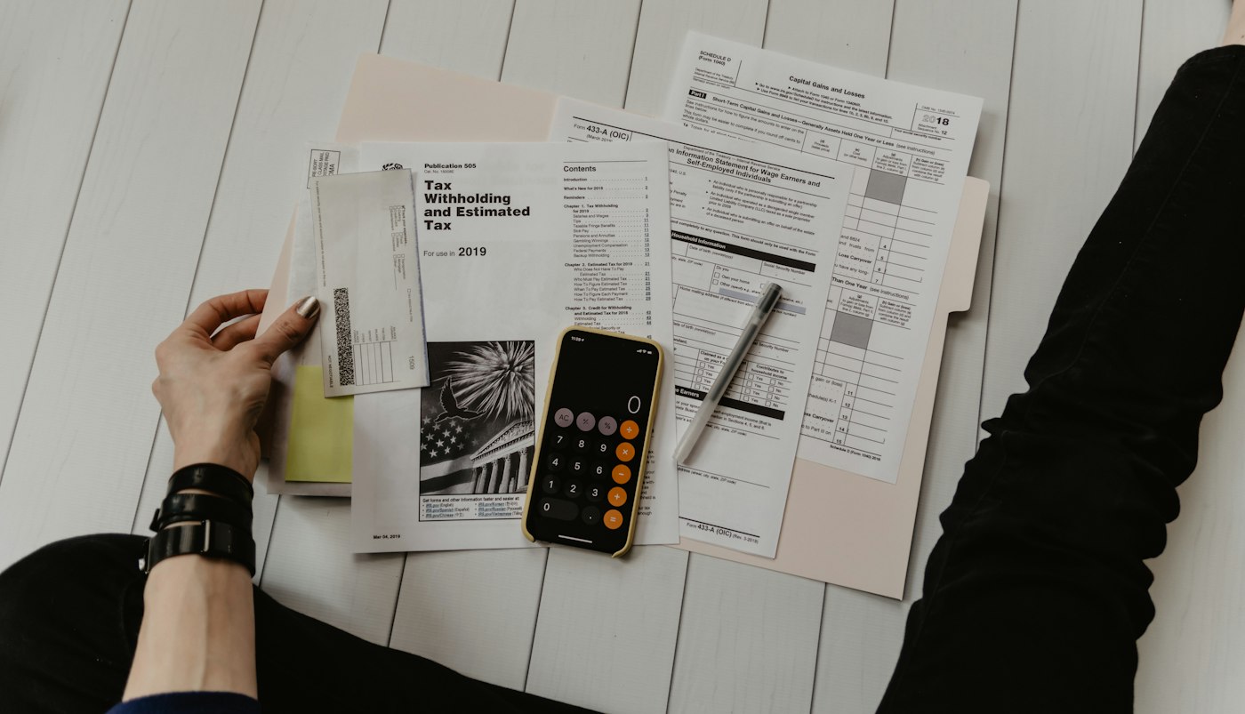Tax papers being checked with a pen and calculator